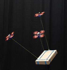 Three drones carry a load together