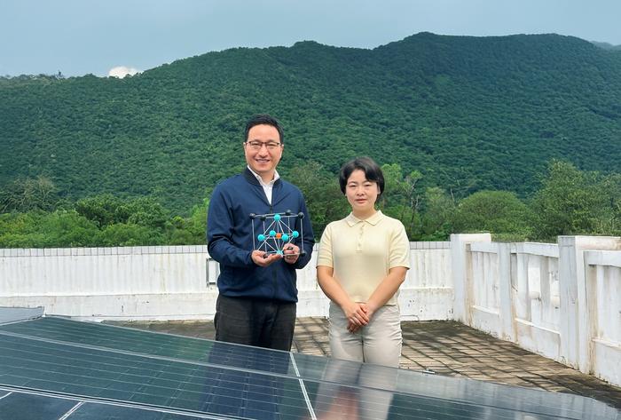 論文的通訊作者周圓圓教授（左；手持鈣鈦礦晶體結構模型）及第一作者段甜偉博士（右）站在太陽能板前。