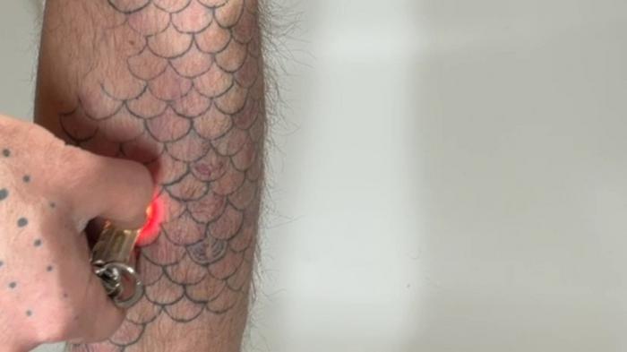Scales tattoo under light