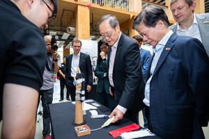 Dr Tan See Leng [centre] and NTU VP (Industry) Prof Lam Khin Yong [right], looking at a smart variable-stiffness glove for rehabilitation