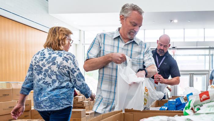 Rob Moore and Scott Retterer pack food bags