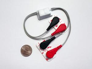 Wearable breastfeeding device next to quarter for scale