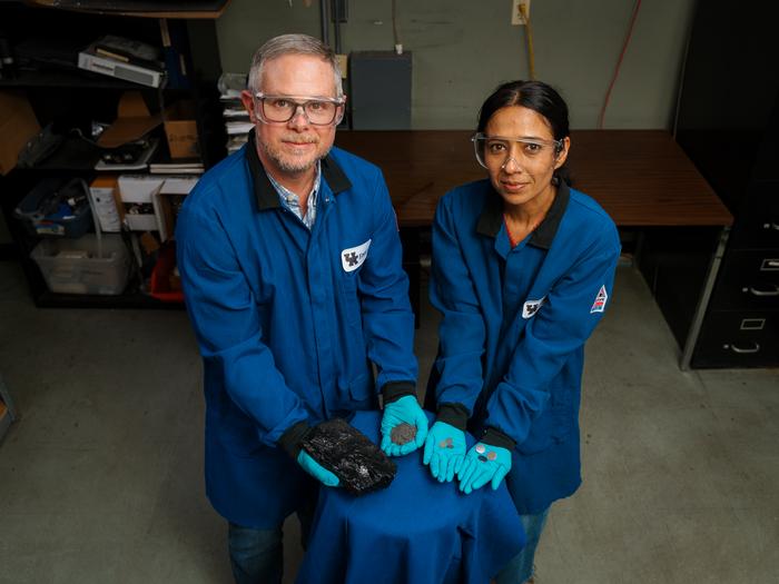 Matt Weisenberger and Aman Preet Kaur hold the progression of coal, from raw resource to finished battery.