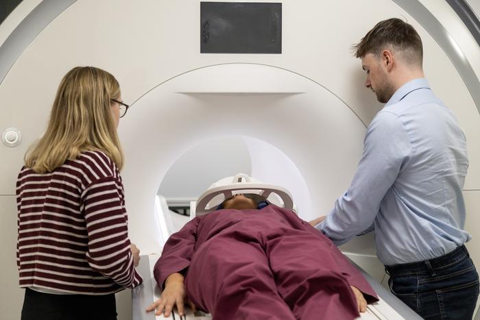 PhD researchers Louisa Wood and Robert Davis prepare rugby athlete Ffion James for an MRI scan
