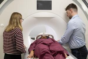 PhD researchers Louisa Wood and Robert Davis prepare rugby athlete Ffion James for an MRI scan
