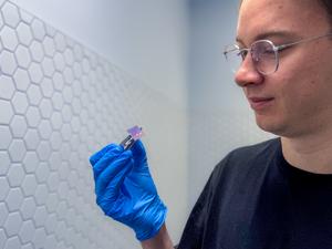 Daniel Tibben holding device. Credit: RMIT