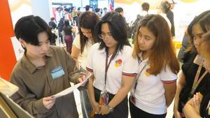 OUS student explains research poster to Mapúa University students