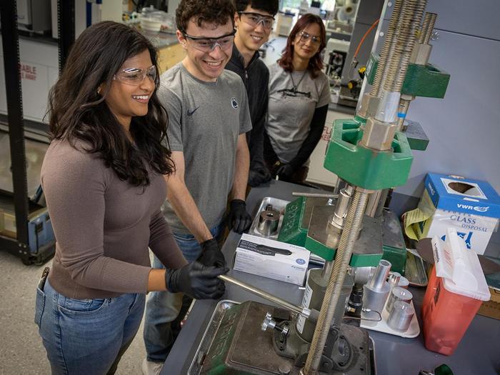 students work with instrument in the lab