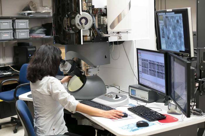 Woman looking through microscope.