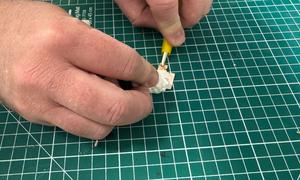 An electrode applies an electric field to a polystyrene layer on a copper sheet, controlling the static charge left on its surface