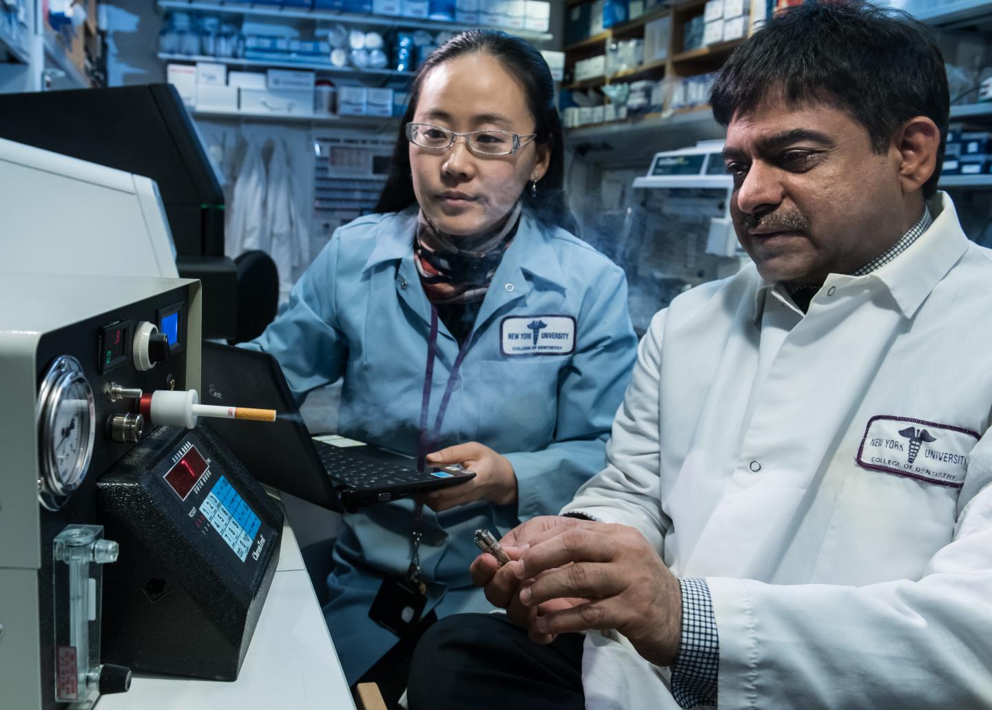 NYUCD Researchers Drs. Deepak Saxena and Xin Li Test the Study's 'Smoking Machine'