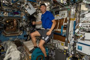 NASA astronaut Chris Williams pedals on the exercise cycle inside the International Space Station’s Destiny laboratory module.