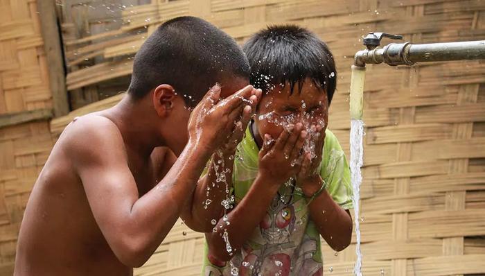 Children cooling off with piped water in Khan Village, Lao PDR in 2015.