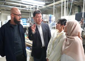 Ogino speaks about research with students and a researcher