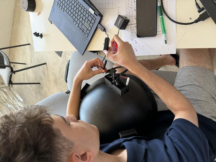 An EXPLORE project student solving a malfunction in the helmet ventilation system