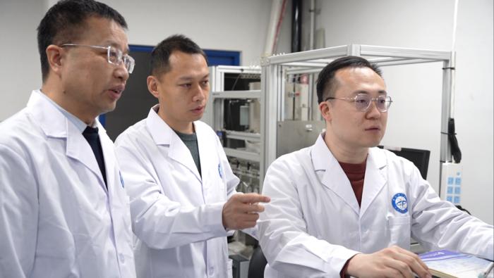 The main authors of the study are discussing experimental data in front of the Fischer–Tropsch synthesis reactor