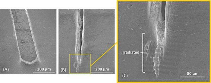 Scanning electron microscopy images showing a wide crack opening (image A) in non-irradiated polyethylene (PE) and minimal crack propagation in PE irradiated with a focused electron beam