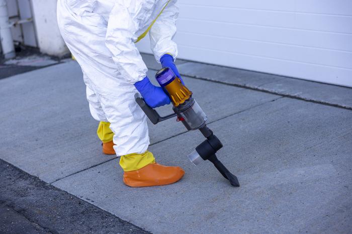 Researcher using the collection device to collect mock nuclear fallout debris.