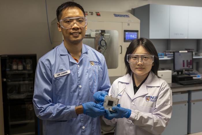 Assistant Professor Lum Yanwei (left) with Yang Qin (right), first author of the research, holding a sample of the catalyst they developed.