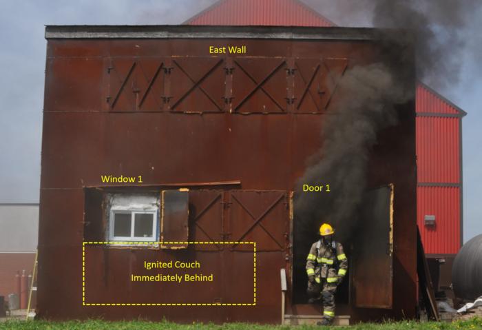 A firefighter exiting a burn house used for concontrolled fire test.