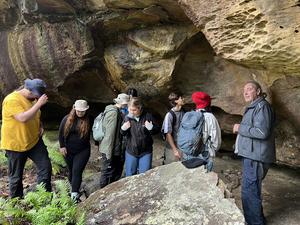Wayne Brennan with University of Sydney students in a rock shelter