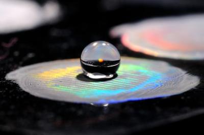 Water Drop Sitting on Hydrophobic Material with Structural Color.
