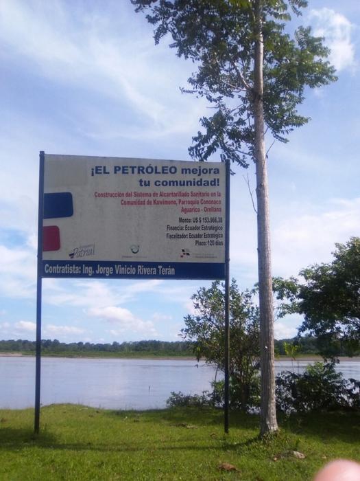 A sign by state oil company Petroamazonas that says “Oil extraction improves your community”