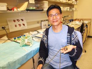 Researcher holding prototype of pediatric heart pump