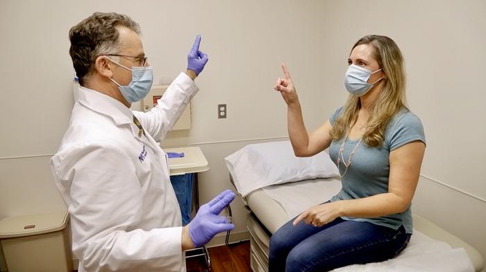 Dr. Igor Koralnik meets with a patient in the Comprehensive COVID-19 Center at Northwestern Medicine