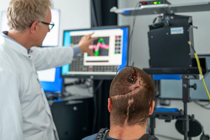 Prof. Simon Jacob and study participant Michael Mehringer discuss data obtained via a brain-computer interface.