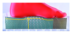 The “Rotating Squares” metamaterial deforms conformally, with the blue grid of right angles remaining at right angles after deformation by a foot shaped object.