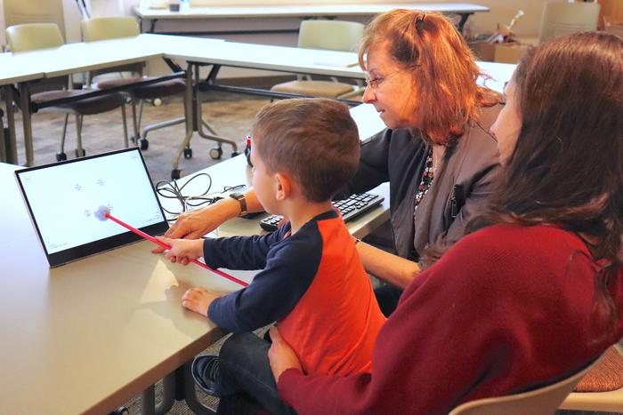 Child pointing at WatDAT screen