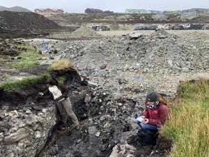 Dr Zoë Thomas and Dr Haidee Cadd examining ditch at Tussac House site where prehistoric tree remains were found