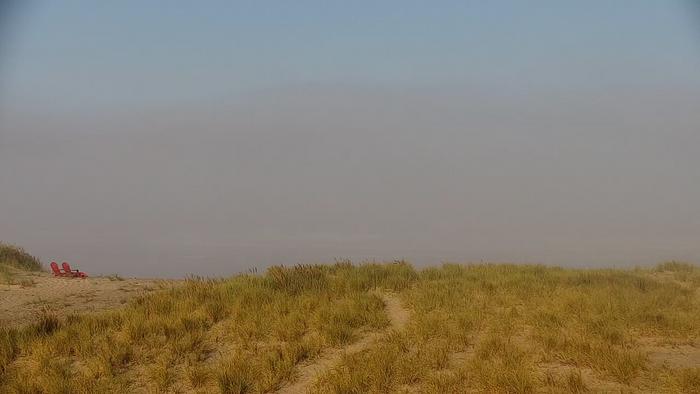 Red chairs on foggy beach