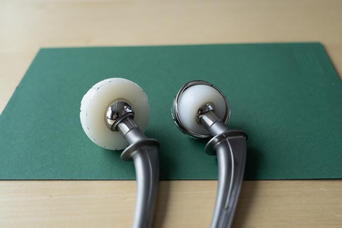 The standard hip replacement to the left, and the dual-mobility total hip replacement (DM‑THR) to the rigtht.
