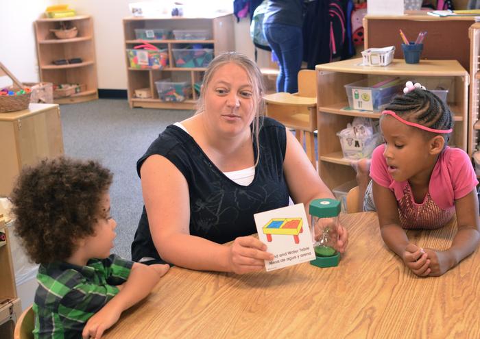 A teacher uses a timer to help children plan learning activities during Plan-Do-Review.