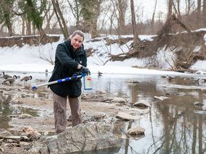 UMD research assistant takes water sample from Potomac