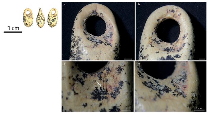 Ivory bead showing the perforation, traces of work and red dye residue