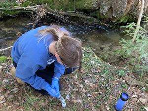 an undergraduate geosciences major takes samples at one of the well sites