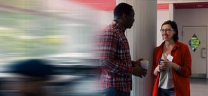Two people are having a conversation in a hallway