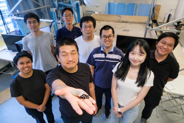NTU Prof Hirotaka Sato (2nd from left), pioneer of the cyborg insect technology, holding a cyborg Madagascar hissing cockroach with the new diving suit