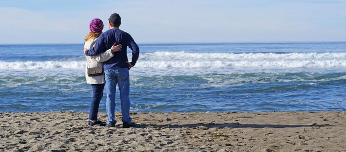 Couple on beach watching waves