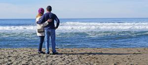 Couple on beach watching waves