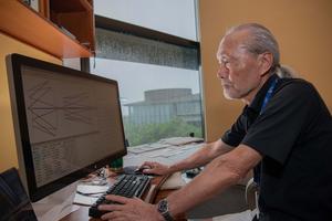 Professor Shintake studies his design for in-line, high-NA EUV lithography