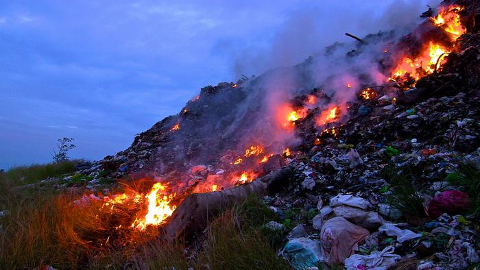 Burning trash in an open dump site in the Philippines