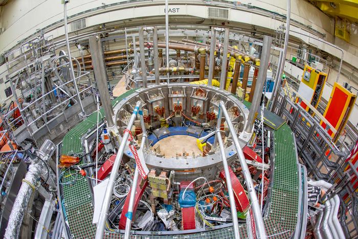 An overhead photo of NSTX-U shows a circular opening where the magnets at the center of the device will be placed.