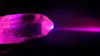 single, brightly lit crystal on black background