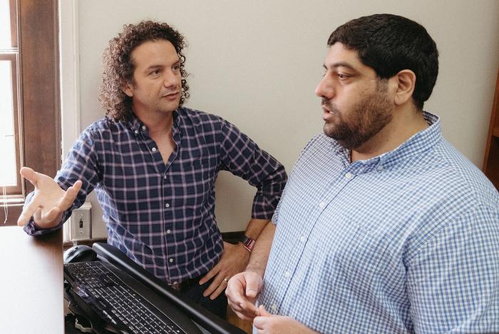 Two men sitting in an office talking with each other