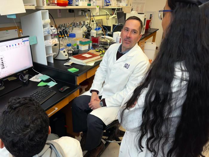 Jeffrey Savas talks to lab members