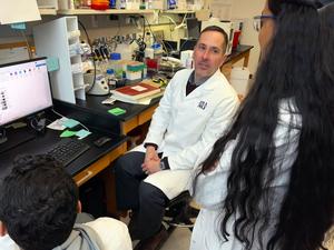 Jeffrey Savas talks to lab members